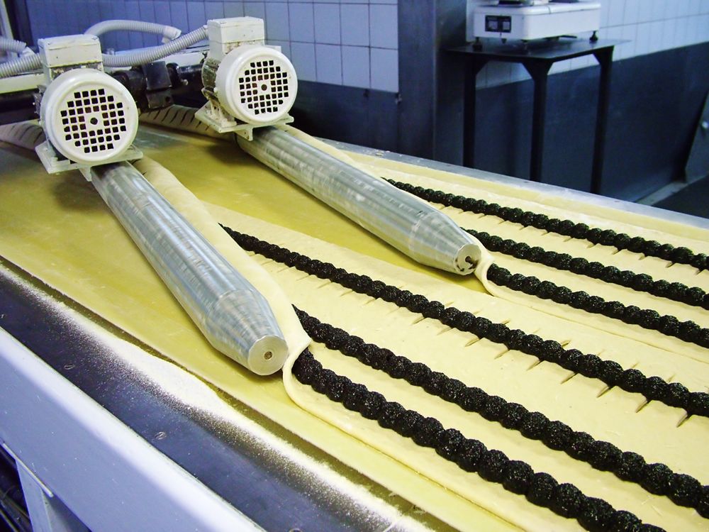 The factory conveyor, which prepares rolls with poppy